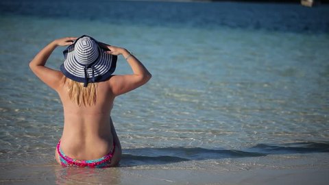 480px x 270px - Young blonde woman sunbathing topless on a beach