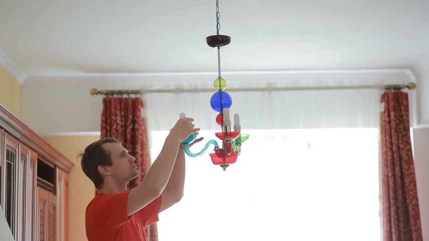 Stock Of Chandelier Ceiling Lamp Swinging In The Event An A Handsome Man Shirt Changes Light Bulb To Crystal Lamp Hd Stock Footage