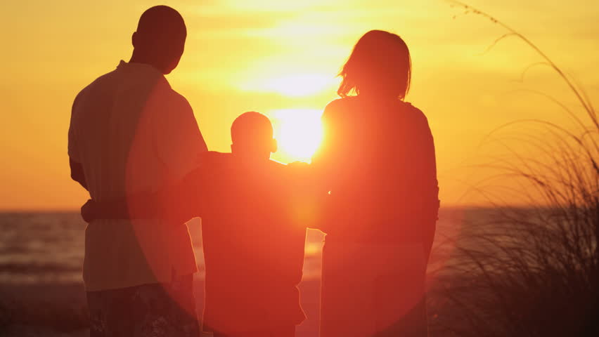 silhouette of carefree african american family enjoying sunset and togetherness on beach vacation 4k stock