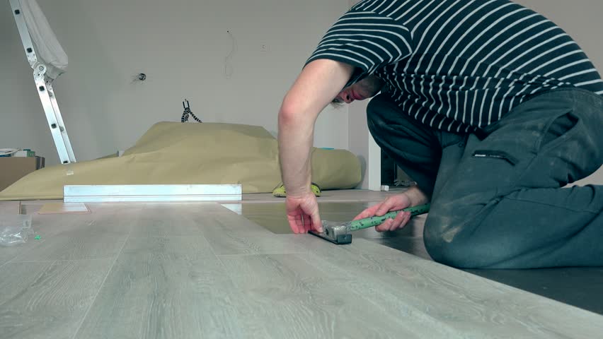 Simple Man Laying Laminate Boards On Floor With Hammer Handheld