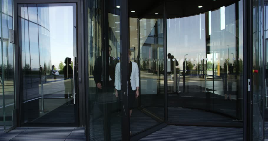 People Using Automatic Revolving Glass Stock Footage 100 4k00 09two Business People Leaving Building Through Spinning Door And Talking