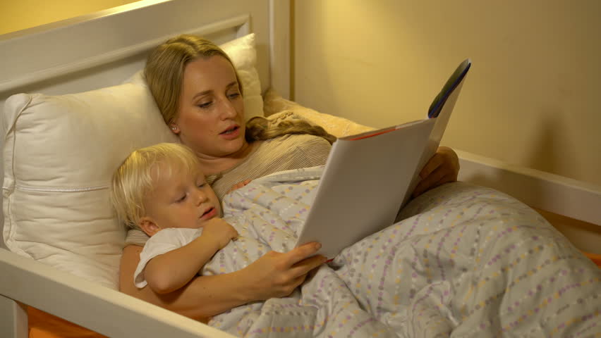 Мать легла спать сыном. Мамочки на кровати. Мать у кровати. Мама на постели читает книжку детям. Мама читает книгу сыну перед сном.