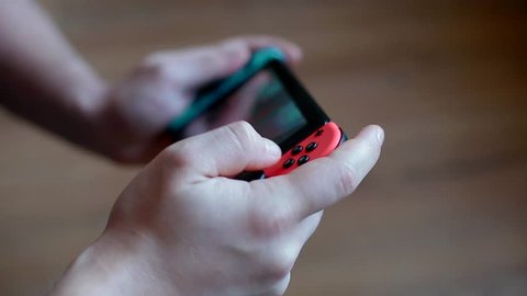 LVIV, UKRAINE - 28 OF JANUARY, 2017 :Young man playing game on Nintendo Switch. Closeup shot.