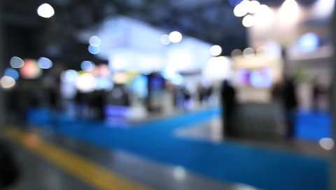 People visit a trade show, generic background. Intentionally blurred editing post production.